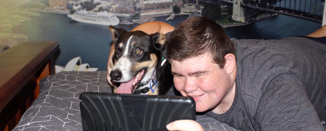 Young man with Loki the Therapy Dog taking a selfie