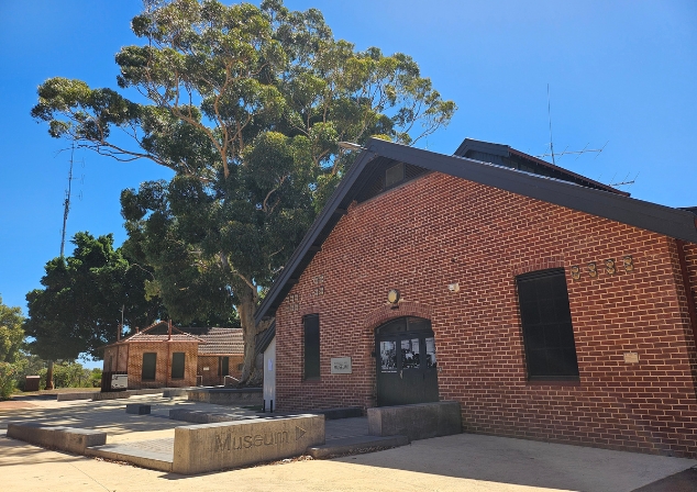 Red brick building, Wireless Hill Museum with big gum tree in the background.