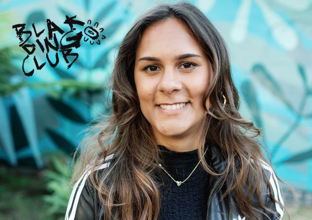 Ilona McGuire smiling in front of a blurred blue and green background with a Blak Dingo Club logo stamped on the image.