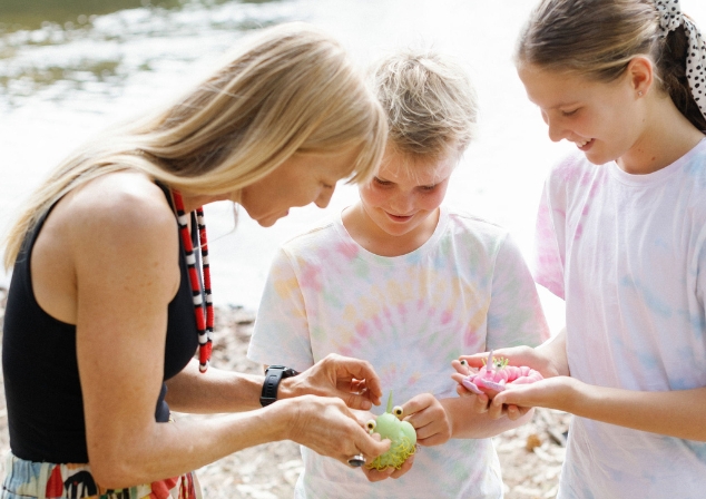 Art teacher Erin Coates and two young students inspecting hand-made neon coloured silicone creatures.