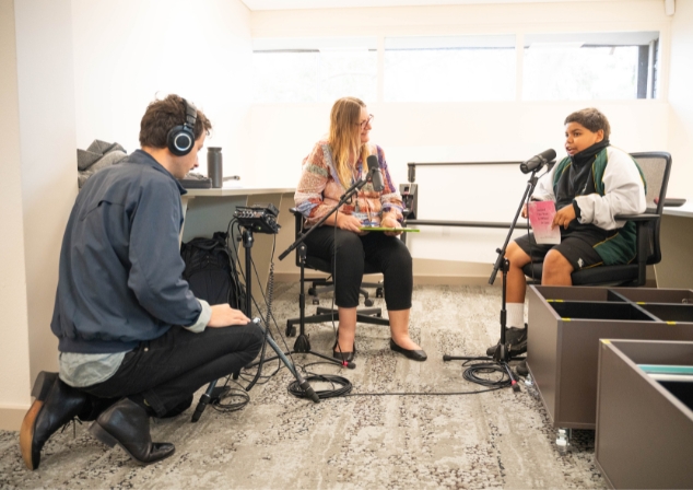 Three people recording a podcast 