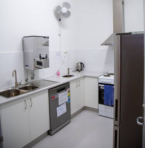 The kitchen includes a hot water system, fridge, dishwasher, microwave and oven