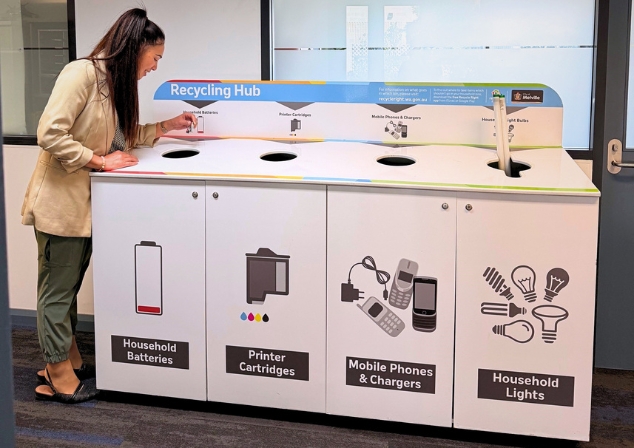 Woman deposits batteries into a Beyond the Bin Recycling Station