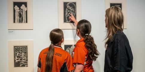 Image of two students and an adult looking at write club work