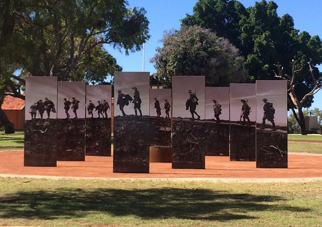 Photo of the War Memorial at Wireless Hill Park. Nine columns at differing distances making up an image of soldiers walking.