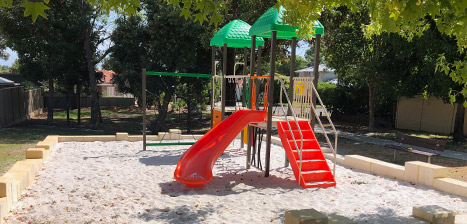Photo of brightly coloured playground in sand pit.