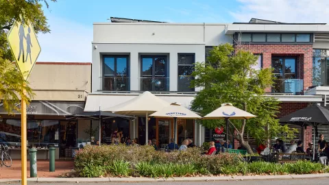 Streetscape image with apartments and cafe strip