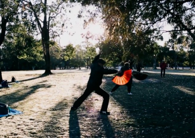 Photo of people stretching and holding handheld fan.