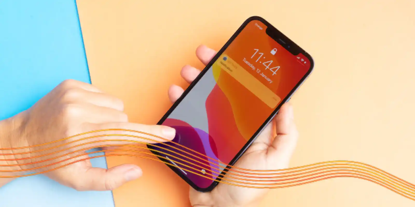 An iPhone held in someone's right hand, while the left hand points to its screen.