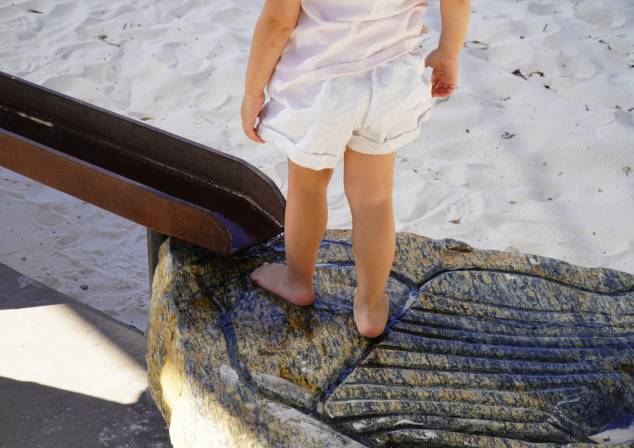 child standing on a rock in the play ground