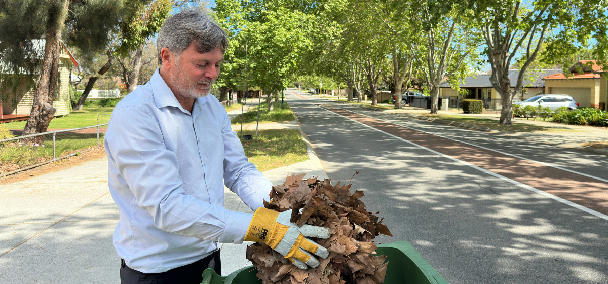 Image of a man putting leaves in FOGO bin