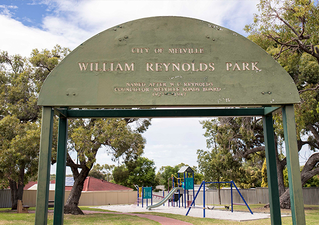 Photo of green archway with text: 'City of Melville, William Reynolds Park, Named after W.C. Reynolds, Councillor - Melville Roads Board 1927-1947'