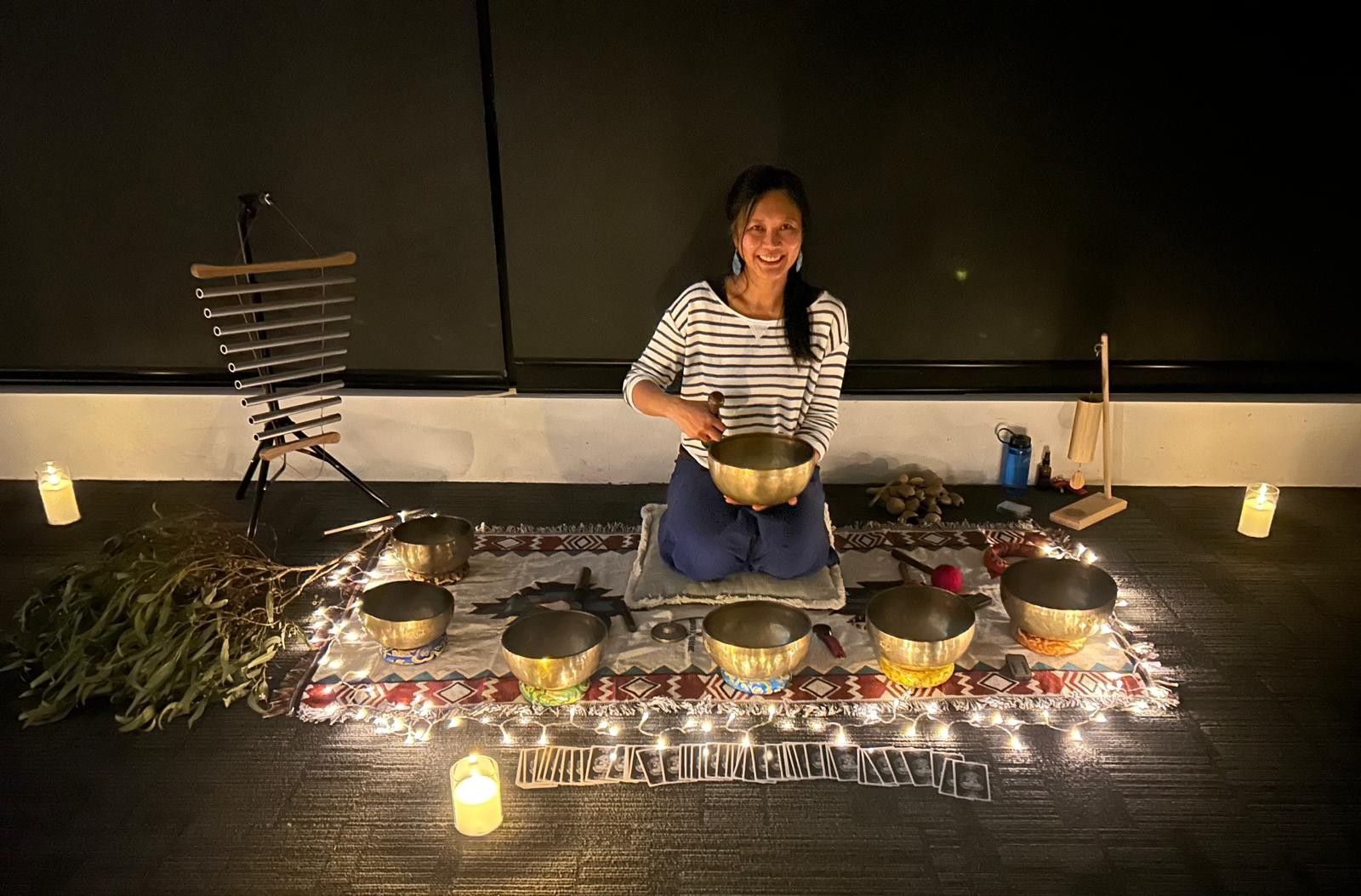 Woman sitting in a circle of Tibetan sound baths