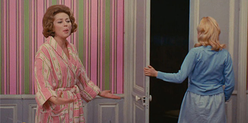 two women stand in a brightly coloured room