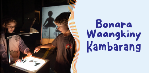 An image of two children using paper cutouts to play with a lightbox.