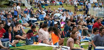 Large group of people sitting on the grass