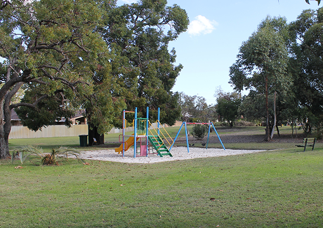 Children's Playground in sand pit with surrounding grassed lawn
