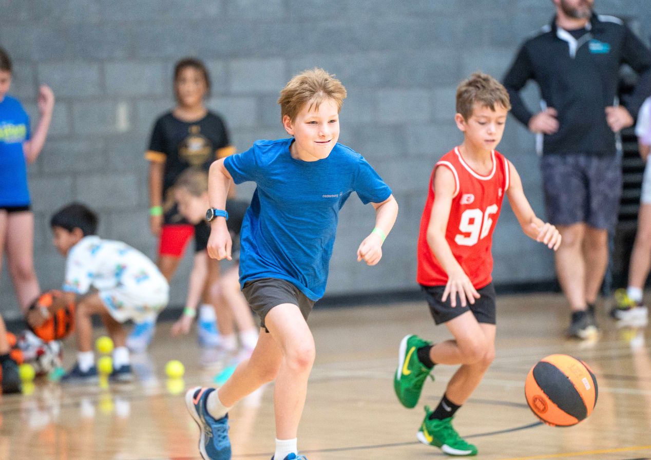 Kids playing with sports balls on a sorts court