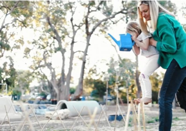 Woman helping child down to water plants
