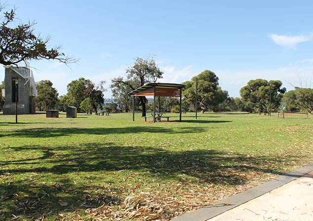 Wide photo of grassy area with gazebo, park benches and other park facilities
