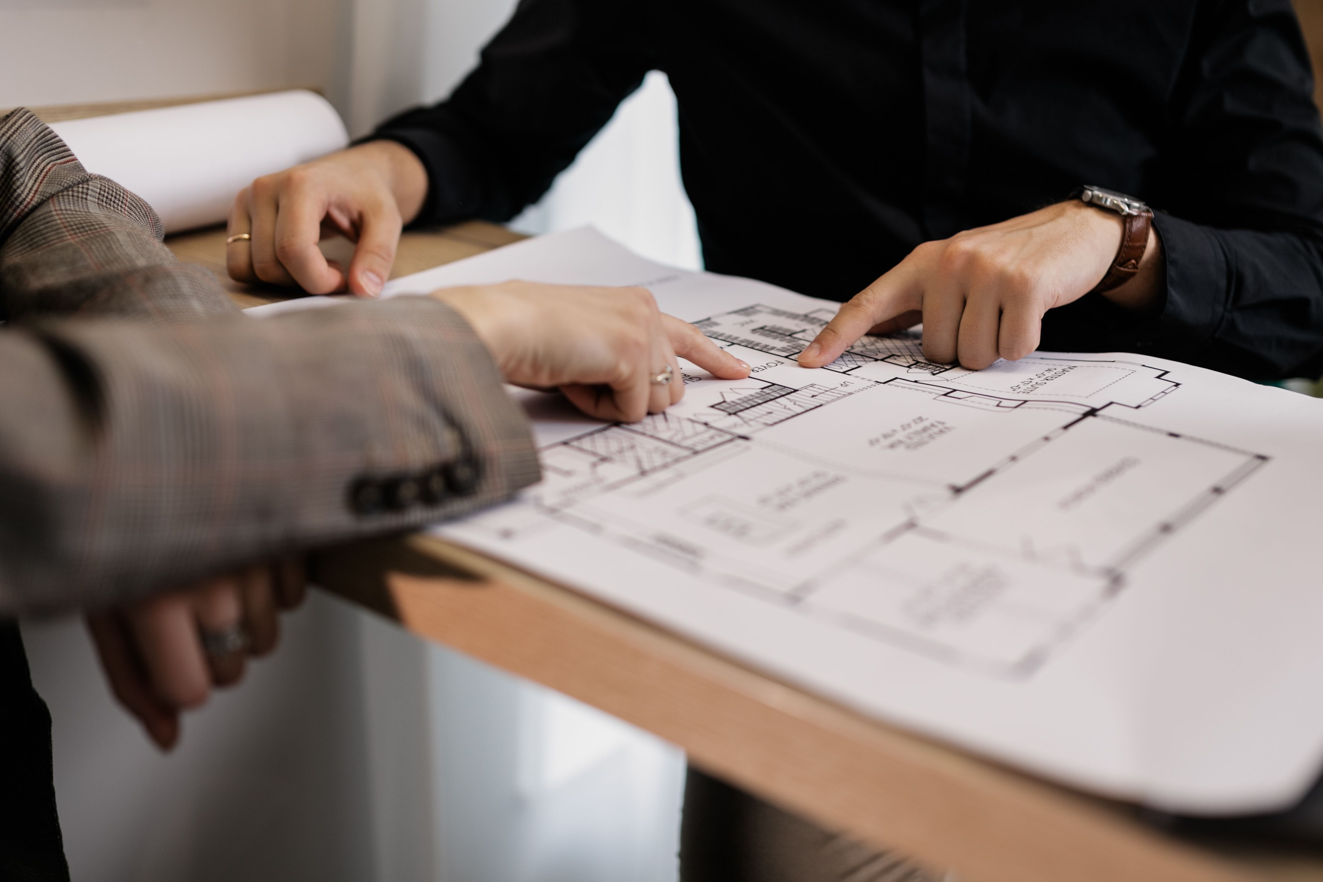 Two hands over a building planning document