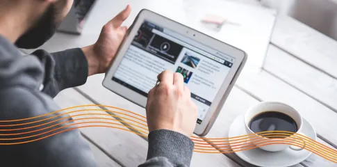 A man's hands hover over a tablet with a web page open displaying information.