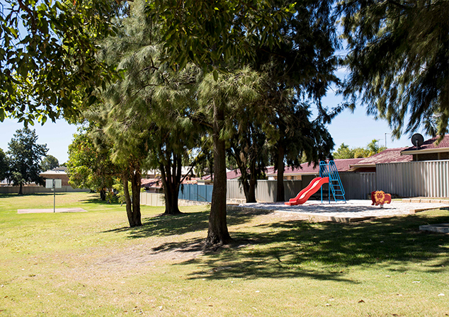 Children's Playground with grassed area and tall trees