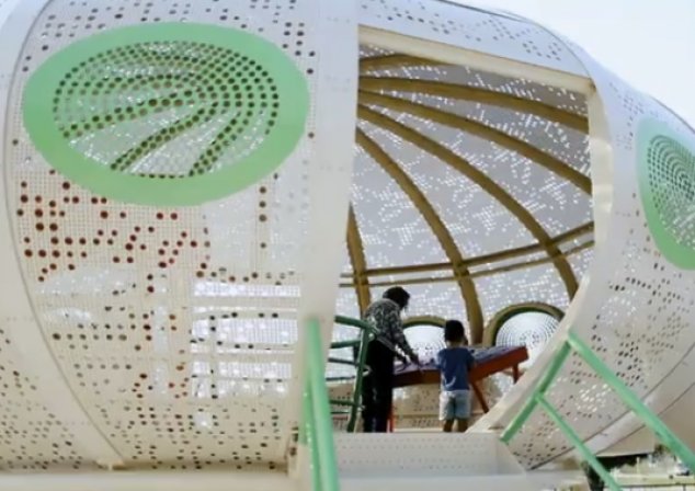 Two people playing inside spaceship playground