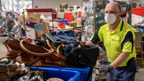 Image of a man wheeling donated items to be sorted